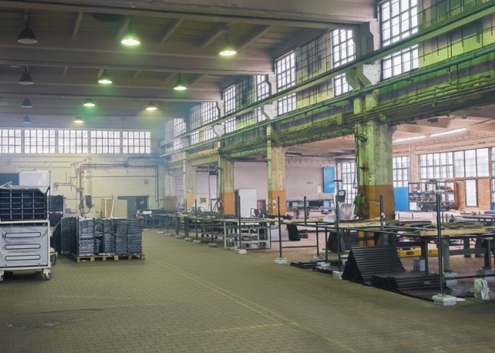 Demontaż maszyny przemysłowej w hali produkcyjnej w Pabianicach