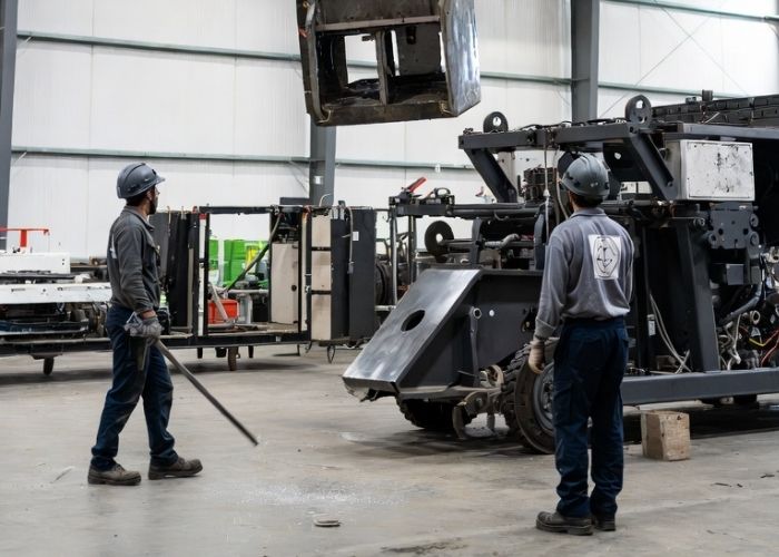 Demontaż maszyny przemysłowej w hali produkcyjnej w Małogoszczu