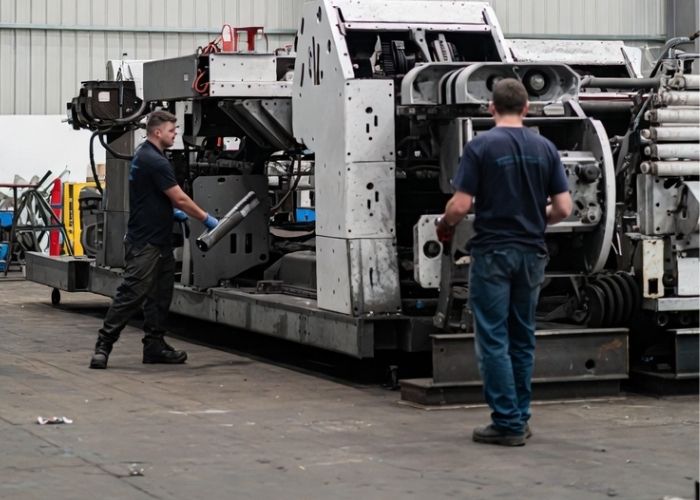 Demontaż maszyny przemysłowej w hali produkcyjnej w Praszce